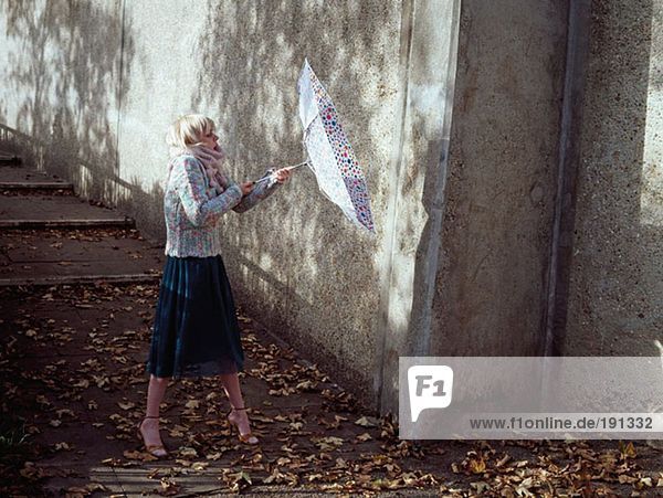 Woman holding inside-out umbrella