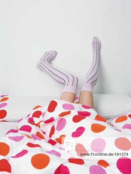 Legs in socks poking out of bed