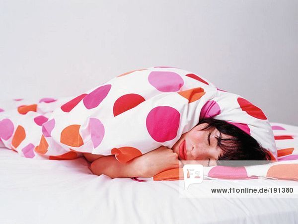 Woman sleeping wrapped up in duvet