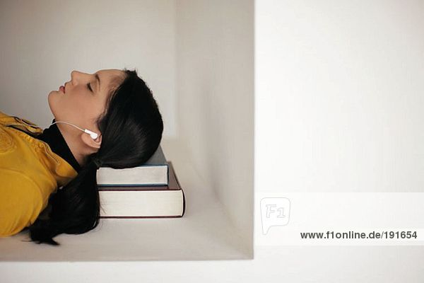 Junge Frau schläft auf ihren Büchern