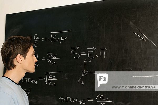 Junger Mann erwägt Gleichung an der Tafel
