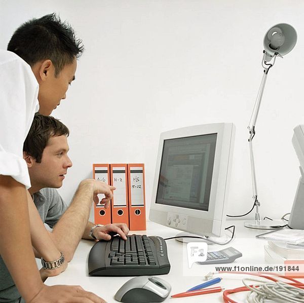 Office workers looking at computer monitor