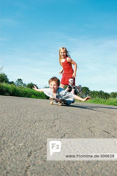 Mädchen schob ihr Bruder auf ein skateboard