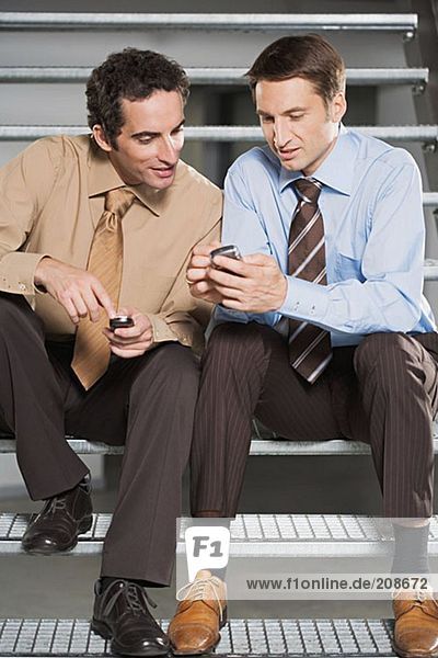 Colleagues comparing mobile phones