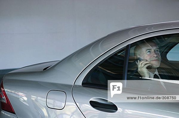 Businessman in a car using mobile phone
