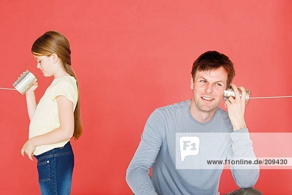 Vater und Tochter mit Blechdose telefonieren