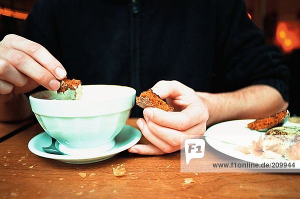 Man dipping biscuits in coffee