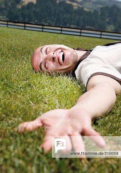 Happy man lying on the grass