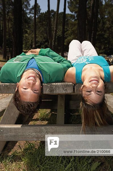 Young couple lying on a picnic table