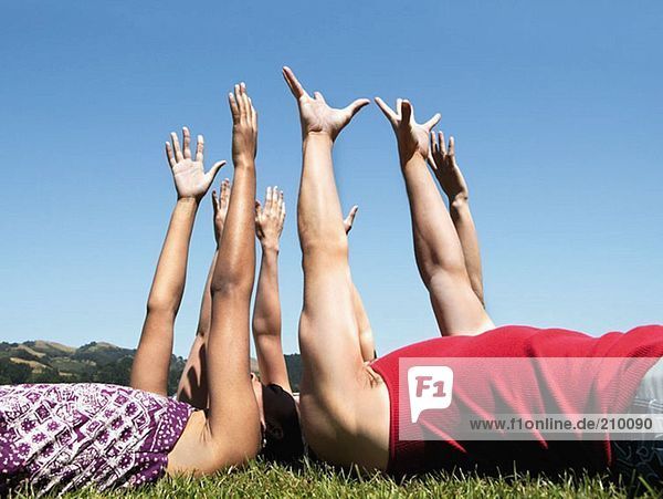 Friends lying down and raising arms