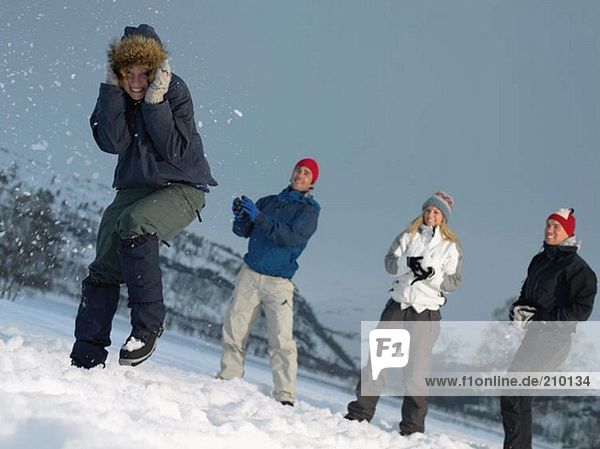 Friends throwing snowballs