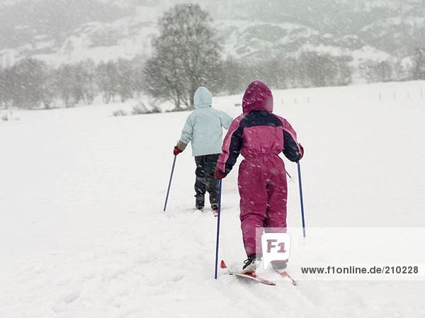 Girls on skis trekking through the snow
