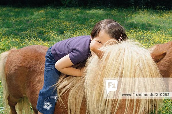 Mädchen auf einem Pony sitzend