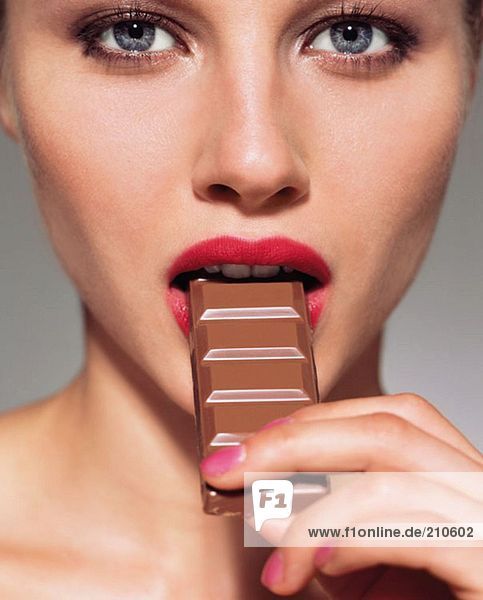 Woman eating bar of chocolate