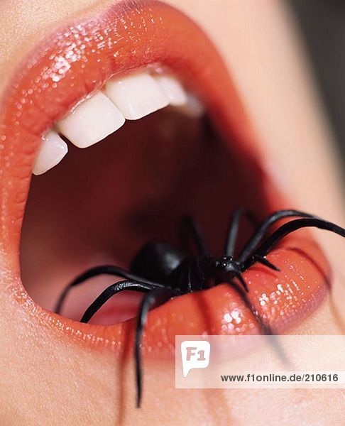 Frau mit Spinne im Mund  im Mund.