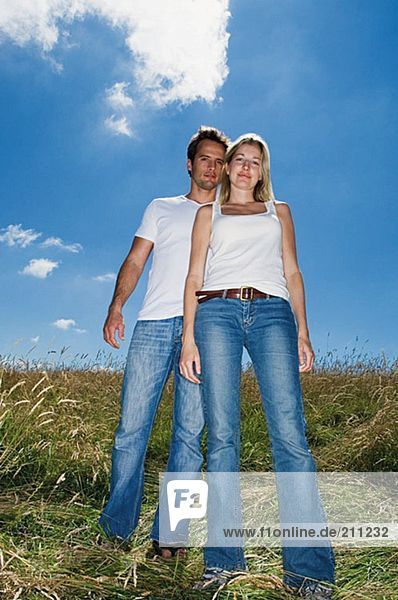 Junges Paar auf einem Feld stehend