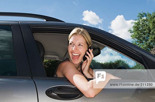 Woman in car using mobile phone