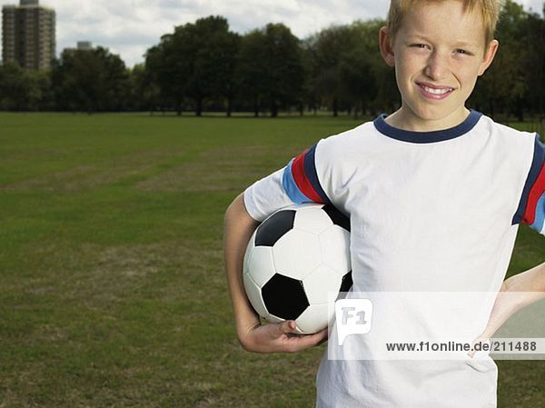 Junge hält einen Fußball