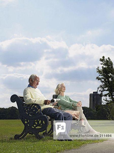 Älteres Paar im Park sitzend