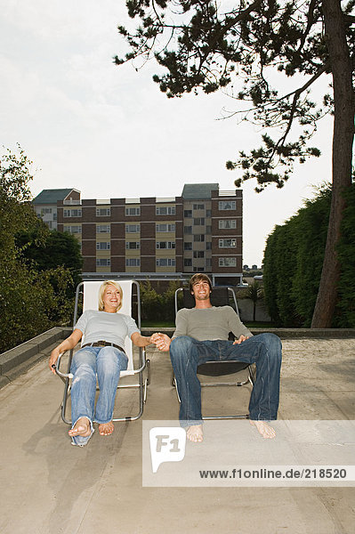 Couple in deckchairs on roof