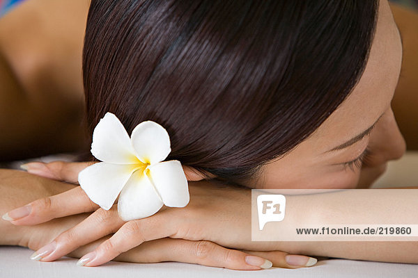Woman with flower in hair lying down