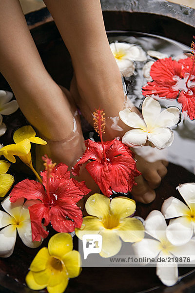Füße der Frau im Blumenbad
