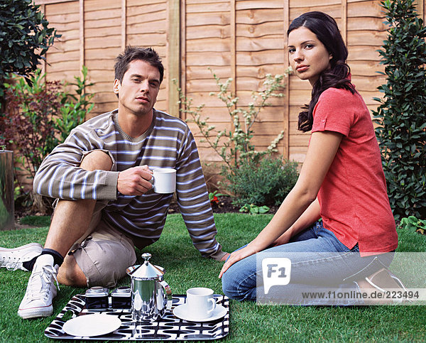 Young couple having coffee in the garden