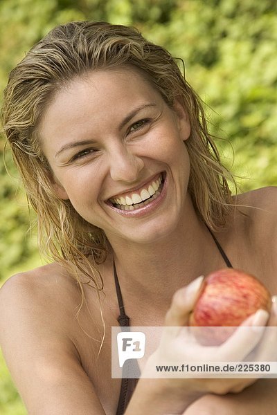 Portrait of woman holding apple and smiling