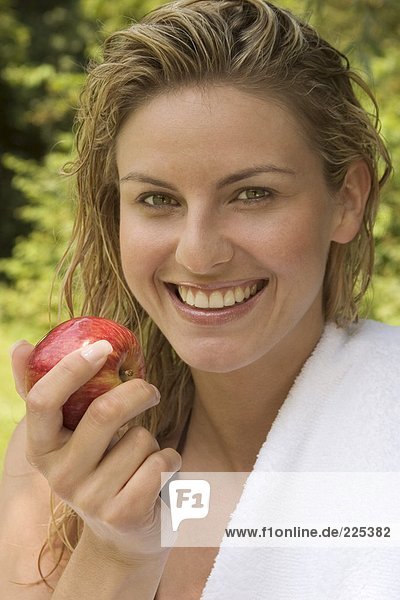 Portrait of woman holding apple and smiling