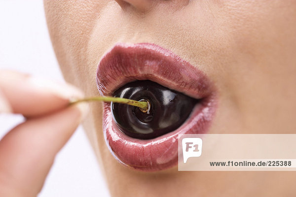 Close-up of woman eating cherry