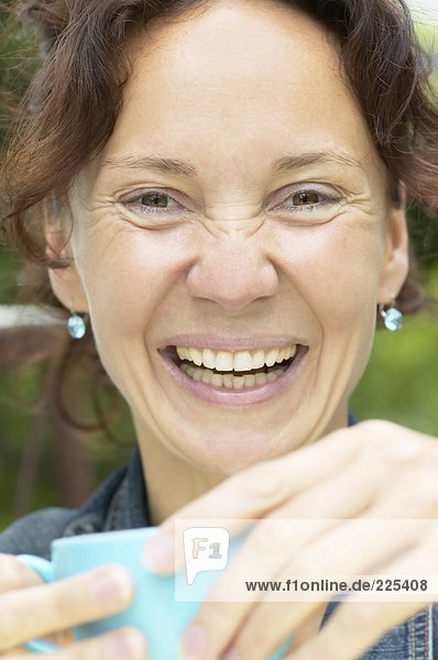 Portrait of woman holding tea cup and smiling