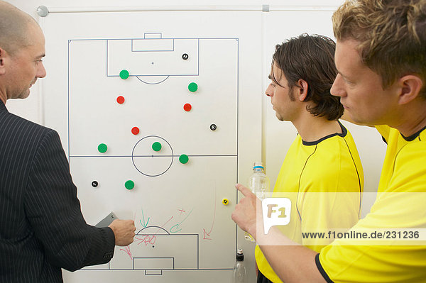 Trainer und Fußballspieler diskutieren Strategie