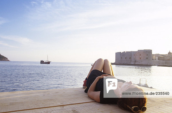 Croatia  Dubrovnik  woman lying on pier