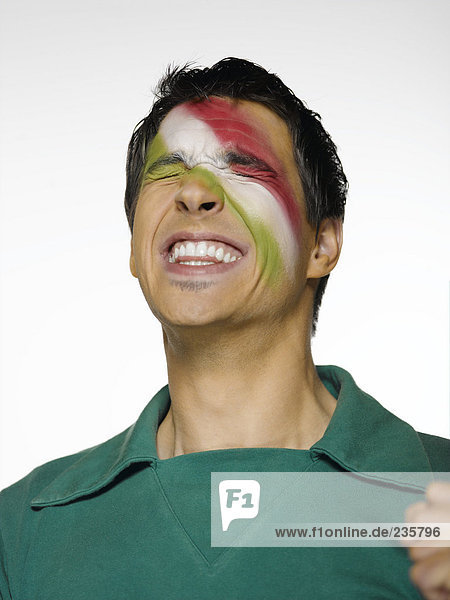Fußballfan mit mexikanischer Flagge auf dem Gesicht bemalt