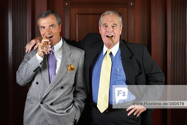 Portrait of two ceo's smoking cigars