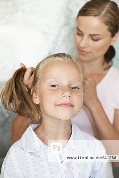 Mother styling her daughters hair