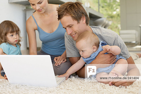 Familie  die einen Laptop benutzt