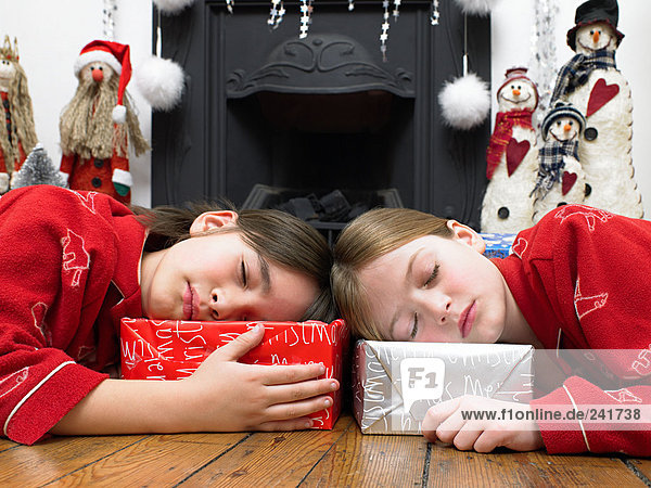 Schlafende Kinder halten sich an ihren Geschenken fest
