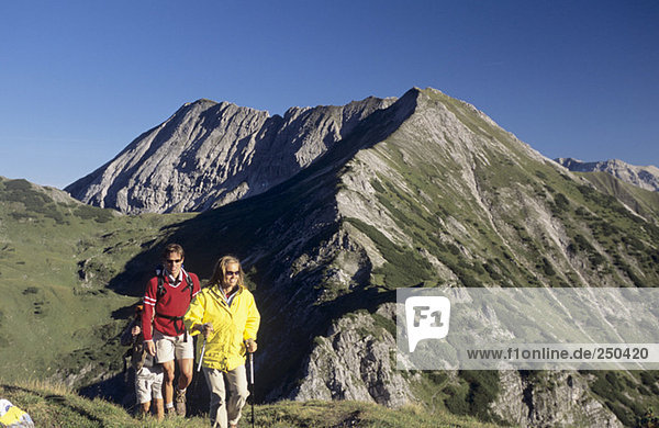 Austria  Salzburger Land  three people hiking in alps