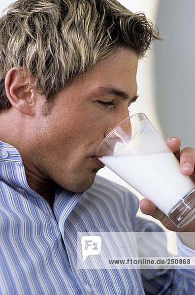 Junger Mann trinkt ein Glas Milch