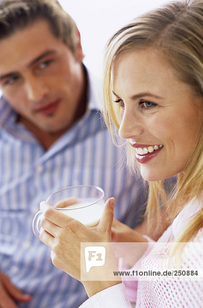 Junges Paar  Fokus auf Frau mit Milchglas
