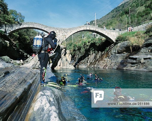 10481902  river diving  diver  near Lavertezzo  river  flow  canton Ticino  Switzerland  Europe  stone bridge  diving  diver's
