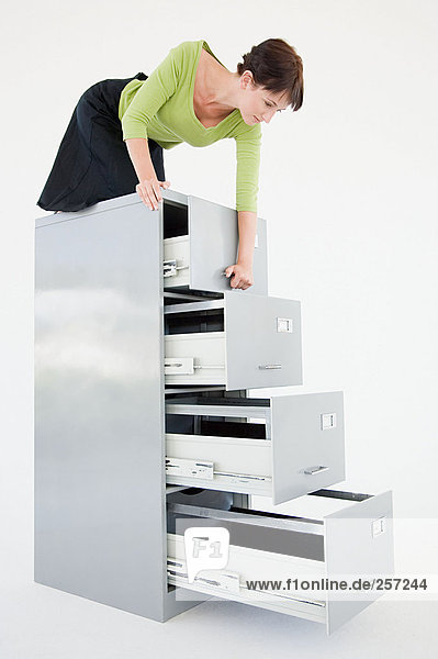 Businesswoman on top of filing cabinet