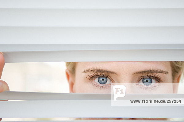 Businesswoman looking through blinds