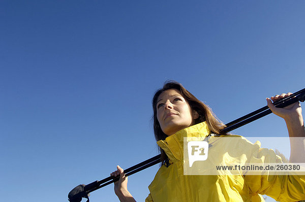 Austria  woman carrying ski pole over shoulder  low angle view