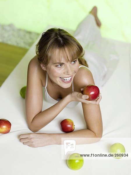 Frau auf dem Bett liegend mit Äpfeln  erhöhte Aussicht