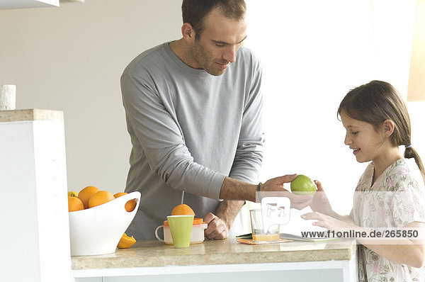 Vater und Tochter in der Küche  Apfel