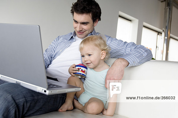 Man and little boy using laptop
