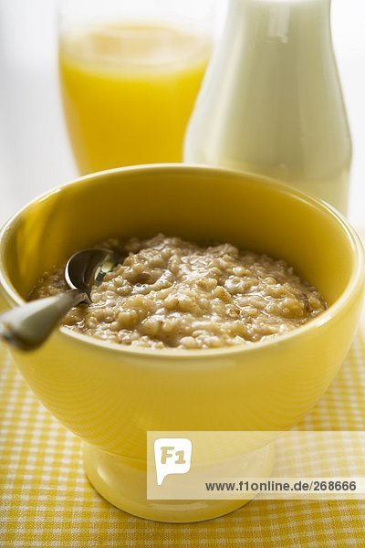 Porridge (Haferbrei)  dahinter Milch und Orangensaft