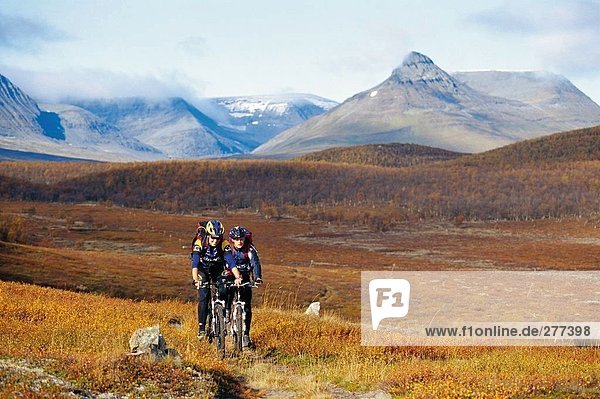 Two people riding mountainbikes in the mountains.